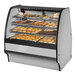 A True curved glass stainless steel dry bakery display case filled with various types of baked goods.