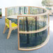 A Whitney Brothers serenity curved divider panel in a child's play area with a tree and a table.