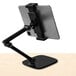 A black Kantek tablet stand holding a tablet on a white surface.