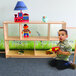 A child playing with toys on a Whitney Brothers wood cabinet shelf.