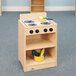 A Whitney Brothers wooden toy stove with a pot and a bowl on it.