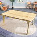 A Whitney Brothers live edge wood table with a wooden base and top.