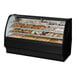 A True curved glass black dry bakery display case with various types of pastries.