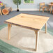 A Whitney Brothers wooden table with a live edge wooden top.