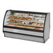 A True curved glass dry bakery display case with pastries.