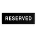 A black rectangular sign with white letters that says "Reserved"