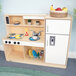 A white wooden Whitney Brothers toddler kitchen combo with a stove, sink, and refrigerator.