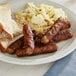 A plate of sausages, scrambled eggs, and toast.