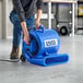 A man using a Lavex blue air mover to clean a floor.