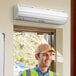 A man in a hard hat smiling at a Boltic air curtain.