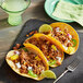 A group of tacos with Better Balance Plant-Based Vegan Ground Beef and vegetables on a slate plate.