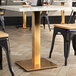 A white marble restaurant table with a gold Art Marble Furniture table base.