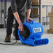 A man using a blue and black Lavex 3-speed commercial air mover to clean a floor.