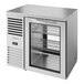 A silver True back bar refrigerator with glass doors.