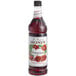 A bottle of Monin Pomegranate Syrup with a label.