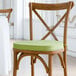 A Lancaster Table & Seating chair with a green Vineyard Series cushion with ties.