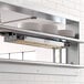 A ServIt double strip warmer on a counter with plates on the shelves.