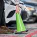 A person holding a Xpose Safety lime green traffic cone.
