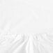 A close-up of a white Garnier-Thiebaut fitted sheet with ruffled fabric on the edges.