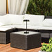 A table with a Globe matte black battery-powered LED table lamp on it outdoors.