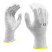 A close-up of a pair of white Cordova warehouse gloves with white polyurethane palm coating.