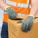 A person wearing Cordova Power-Cor cut-resistant gloves holding a box.