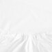 A close-up of a white Garnier-Thiebaut full size fitted sheet with a ruffled edge.