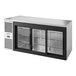 A True stainless steel back bar refrigerator with sliding glass doors.