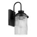 A black outdoor wall sconce with cylindrical ribbed glass shade.