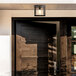 A modern door with a Globe matte black outdoor light fixture on the ceiling.