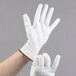 A pair of hands wearing small white Cordova Mirage gloves with white polyurethane palms.