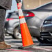 A person holding a Xpose Safety heavy-duty traffic cone with double reflective collars.