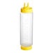 A clear plastic Vollrath squeeze bottle with a yellow Twin Tip cap.