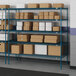 A blue metal Lavex Pro wire shelving unit with boxes on shelves.