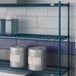 A blue Lavex Pro wire shelf with containers and cans on it.