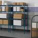 Blue metal Lavex Pro wire shelving with white boxes on the shelves.