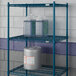 A Lavex Pro blue metal wire shelf with containers on it.