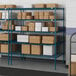 Lavex Pro blue wire shelving unit with boxes on the shelves.