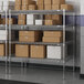 A metal wire shelving unit with brown and white boxes on the shelves.