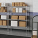 A metal Lavex Pro wire shelving unit with white boxes on the shelves.