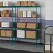 Blue metal Lavex Pro wire shelves with boxes on them.