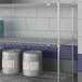 A Lavex Pro chrome metal NSF wire shelf with containers on it.
