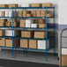 Blue metal Lavex Pro wire shelving in a warehouse with boxes on the shelves.