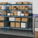 Blue metal Lavex Pro wire shelving with white boxes on the shelves.