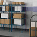 Blue metal Lavex Pro wire shelving with boxes on the shelves.