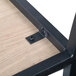 A BFM Seating Memphis steel side chair frame with screws on a wood surface.