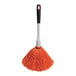 An orange and black OXO Good Grips delicate duster with a white handle.