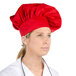 A woman wearing a red Intedge chef hat.