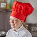 A woman wearing a red Intedge chef hat.