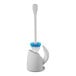 An OXO Good Grips gray toilet brush with blue and white bristles in a white holder.